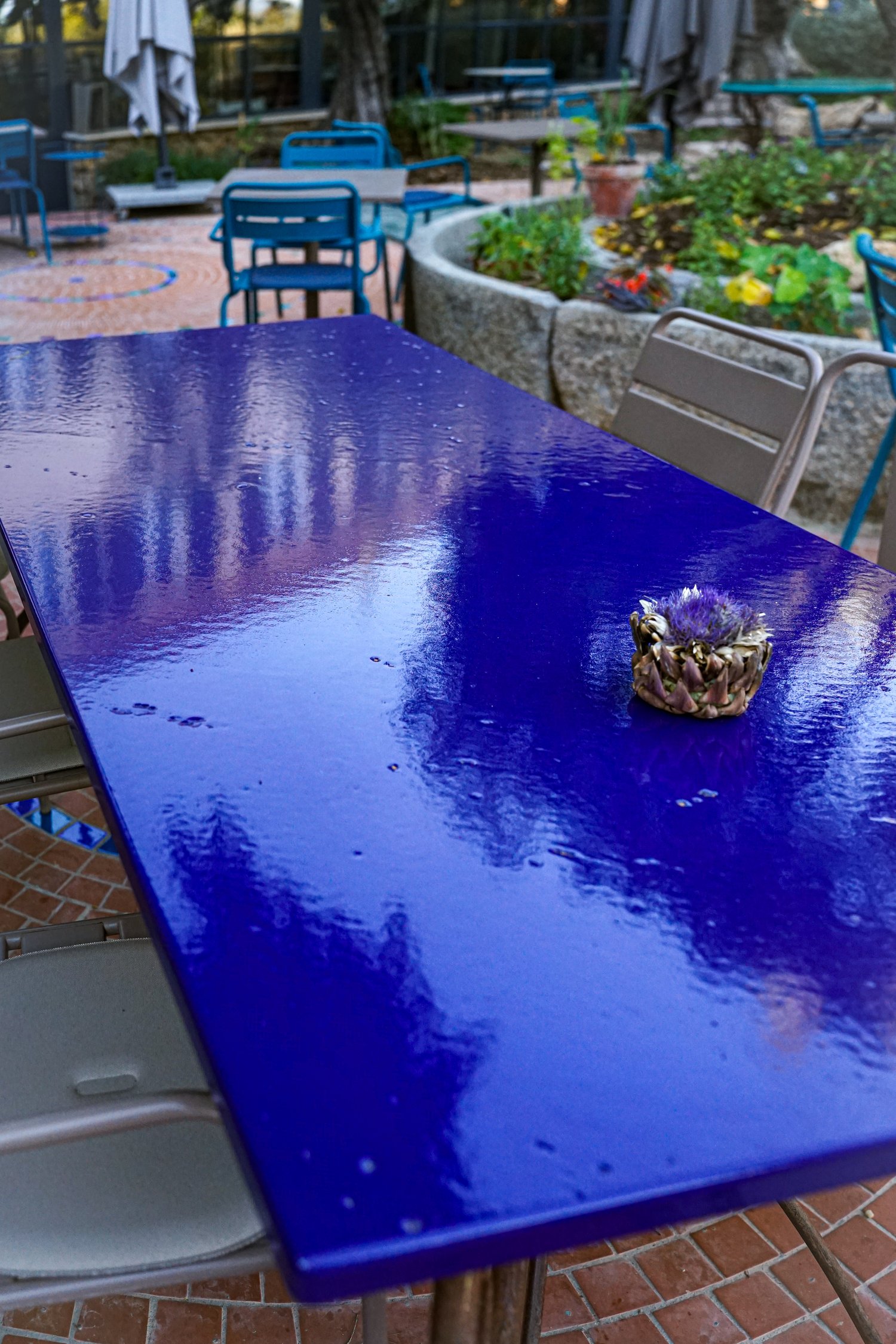 Table rectangulaire en lave émaillée bleu nuit avec une fleur d'artichaut séchée
